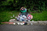 Trash bin with trash on the street. Original public domain image from Flickr