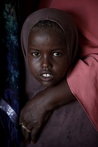 A young Somali girl waits inside a tent where Ugandan soldiers and doctors serving with the African Union Mission in Somalia (AMISOM) were providing free medical check-ups and treatment in the Kaaran district of the Somali capital Mogadishu. Original public domain image from <a href="https://www.flickr.com/photos/au_unistphotostream/6840599393/" target="_blank">Flickr</a>