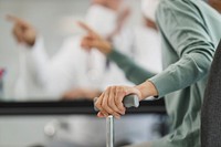 Close up of elderly person hand holding walking cane in hospital, free public domain CC0 photo.