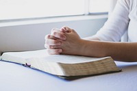 Free hands praying on bible photo, public domain CC0 image.