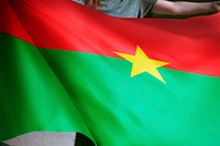 Person holding Burkina flag background, national symbol