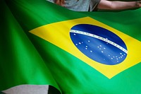 Person holding Brazilian flag background, national symbol