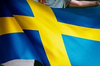 Person holding an Swedish flag background, national symbol