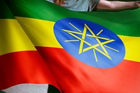 Person holding Ethiopian flag background, national symbol