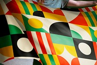 Person holding Bauhaus inspired patterned flag background