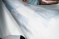 Person holding white world map flag