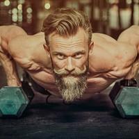 Bearded strong man weightlifting at the gym