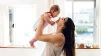 Young mom holding her baby in the air