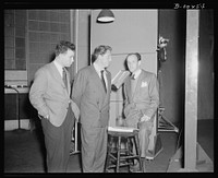 Philip Martin, Jr., technical director, Spencer Tracy, narrator and Garson Kanin, director, at the Long Island Studios of the Army Signal Corps for the recording of Spencer Tracy's narration of the "Ring of Steel," an Office of Emergency Management (OEM), film on on February 19th, 1942. Sourced from the Library of Congress.