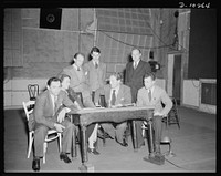 Jack Schaindlin, musical director, Eleanor Herring, Garson Kanin, director, Wallace Russell, writer, Spencer Tracy, narrator, Max Brasch, film editor, Philip Martin, Jr., technical director, at the Long Island Studios of the Army Signal Corps for the recording of Spencer Tracy's narration of the "Ring of Steel," an Office of Emergency Management (OEM) film, on February 19, 1942. Sourced from the Library of Congress.