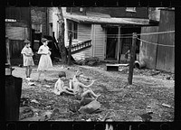 [Untitled photo, possibly related to: Slum children at play, Washington, D.C. Children in their backyard near the Capitol. This area inhabited by both black and white]. Sourced from the Library of Congress.