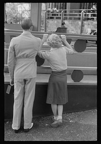 Glen Echo, Maryland. A young couple watching people on "the whip," at Glen Echo Park. Sourced from the Library of Congress.