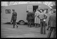 Washington, D.C. A demonstration of FSA (Farm Security Administration) trailers. Bystanders and police escort inspecting a trailer. Sourced from the Library of Congress.