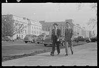 A view of the circular walk leading from the Benjamin Franklin Post Office on the 12th Street side, near Pennsylvania Aveenue, showing pedestrians. Sourced from the Library of Congress.
