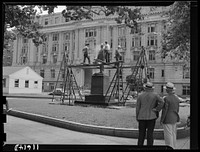 Washington, D.C. Workmen from a monument cleaning company cleaning Shepherd's statue at 14th and E Street, N.W.. Sourced from the Library of Congress.