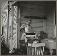 Farm woman washing clothes in her motor-driven washing machine. Near Lincoln, Vermont. Sourced from the Library of Congress.