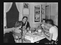 Mrs. Marinus W. Hansen, wife of Farm Security Administration rehabilitation farmer in Box Elder County, Utah, has dinner with her three children. On the table are home-produced milk, homemade bread, home-canned peaches, home-churned butter and fish caught by the three children the day this picture was taken. Homemade dill pickles provided a relish. Sourced from the Library of Congress.