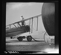 [Untitled photo, possibly related to: Loading "dust" (insect spray) into plane of agricultural crop spraying outfit. This particular group of flying insect killers follow the seasons from Florida to Jersey to New York State. Planes are usually old (new planes with sufficient carrying capacity are too fast). The front seat is taken out and replaced by the "hopper" which contains the dust. Seabrook Farms between Bridgeton and Vineland, New Jersey]. Sourced from the Library of Congress.