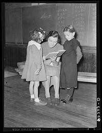 Lancaster County, Pennsylvania. Martha Royer teaching two first graders in her one-room schoolhouse. There are fourteen pupils in the school and the grades run from first to second year high school. The little girl on the right comes from an Amish family. Sourced from the Library of Congress.