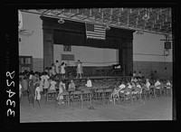 Charlotte Court House, Virginia. Central High School. A combination gym and auditorium where the seats are movable. The elementary school has no auditorium so the children have come over to pratice an operetta. Sourced from the Library of Congress.