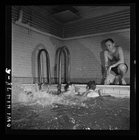 New York, New York. Irving Haeinowits, swimming instructor, giving instructions to two men in the pool at the Lighthouse, an institution for the blind, at 111 East Fifty-ninth Street. Sourced from the Library of Congress.