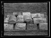 Boston and Maine railroad shops at Billerica, Massachusetts. Almost a ton of lead in this small pile will be used over and over again. This lead was taken out of the locomotive drives wheels (see negative 1 [i.e 54699]) and is used to give wheel flywheel effect. Sourced from the Library of Congress.