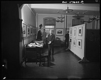 Installation of the United States Office of War Information (OWI) exhibit of original drawings and paintings by artists now in the armed forces. Preview, before shipping to Australia, held at the office of the Overseas Picture Division in the Auditor's Building. Sourced from the Library of Congress.