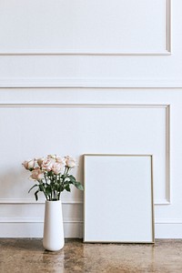 Frame against a white wall by a vase of flowers