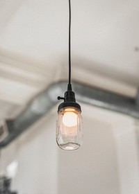 Mason jar lightbulb hanging from a ceiling