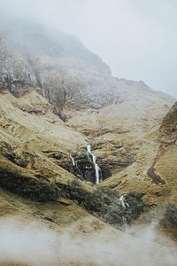 Fog covering a narrow waterfall in Scotland