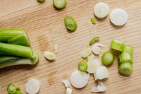 Freshly chopped leek on a wooden chopping board flatlay