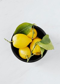 Fresh lemons in a black bowl flatlay