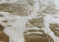 Frothy beach waves in motion