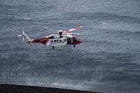 Coastguard helicopter flying over the sea in Scotland