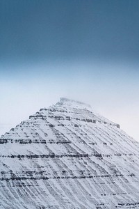 View of snowy Hvíthamar mountain in the Faroe Islands on a misty day