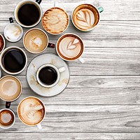 Various coffee cups on a gray wooden textured panel