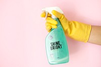 Closeup of hand in glove holding cleaner spray bottle