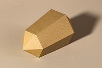 Golden hexagonal prism paper craft on a beige background