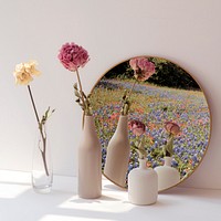 Dried flowers in minimal vases by a round mirror