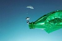 Green plastic bottle polluting the ocean