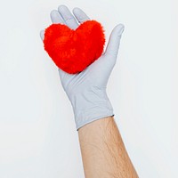 Gloved hand holding a fluffy red heart