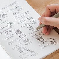 Girl doodling and making a checklist in a notebook