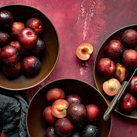 Red plums in a bowl summer food flatlay