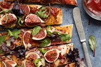 Pizza with tomatoes ham mozzarella and figs flat lay sliced up