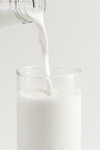 Close up of pouring fresh milk into a glass