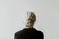 Senior woman facing a gray wall