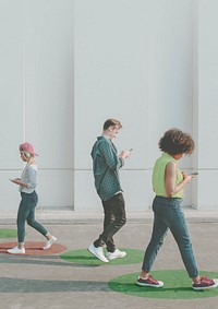 Young adults using smartphones as they are walking outdoors