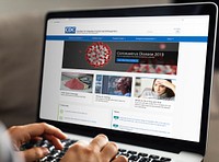 Woman reading coronavirus updates from a laptop mockup with editorial graphic from <a href="https://www.cdc.gov/" target="_blank">https://www.cdc.gov</a> accessed on April 8th 2020. BANGKOK, THAILAND - FEBRUARY 23, 2018