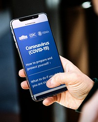 Woman reading coronavirus information from a phone mockup with editorial graphic from <a href="https://www.coronavirus.gov/">https://www.coronavirus.gov/</a> accessed on April 8th 2020. BANGKOK, THAILAND - JANUARY 19, 2018