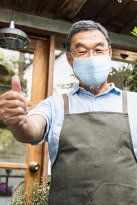 Japanese shop owner in face mask new normal post covid 19